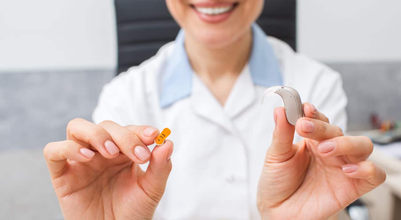 Audiologist holding up a hearing aid.