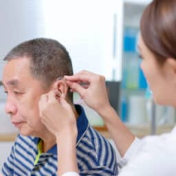 Man being fit for a hearing aid to help with his tinnitus