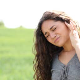 Woman with tinnitus holding her ear