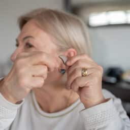 Woman showing off her hearing aid