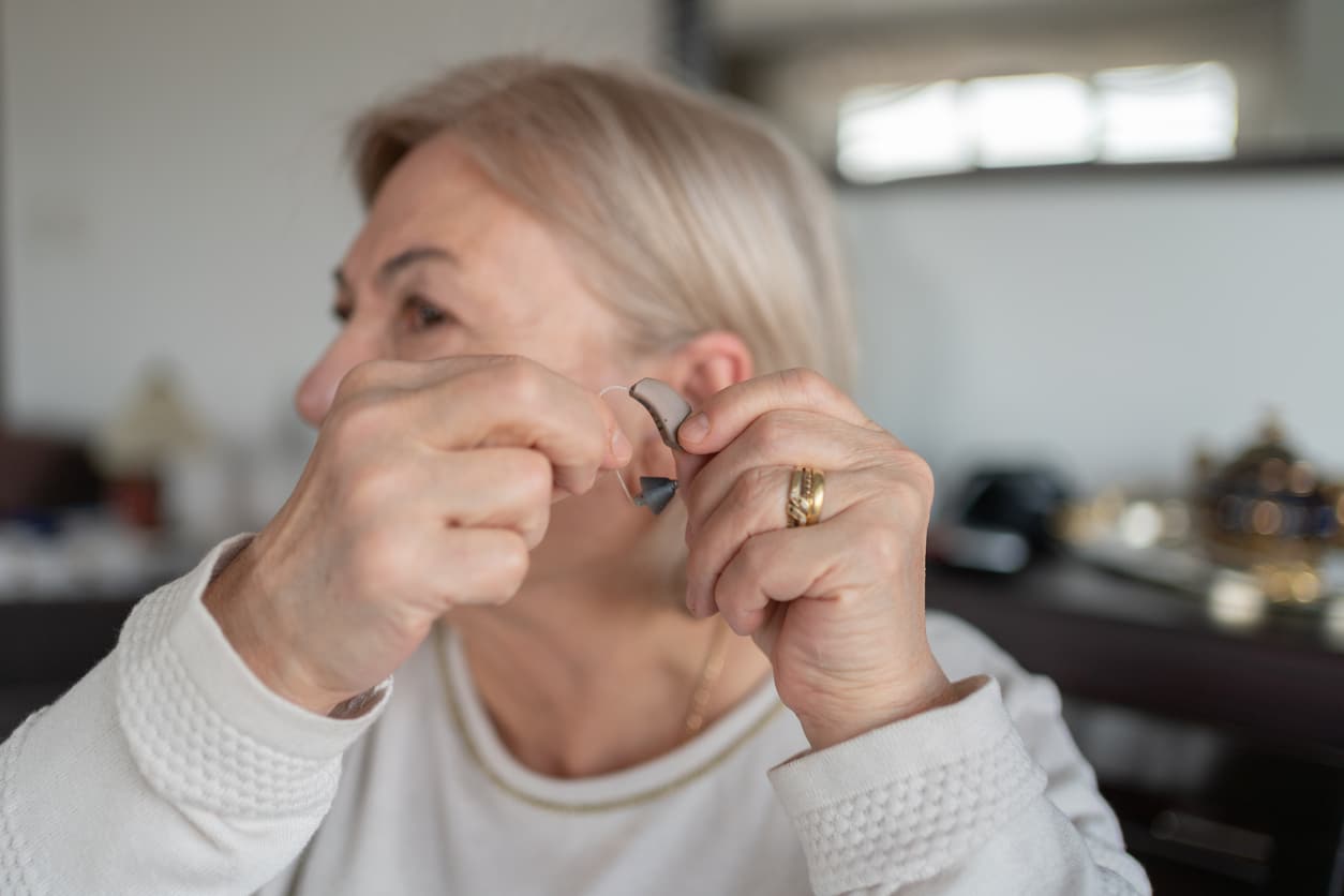 Woman showing off her hearing aid.