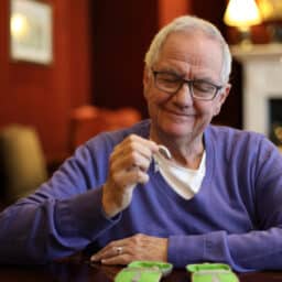 Senior man looking at his hearing aid